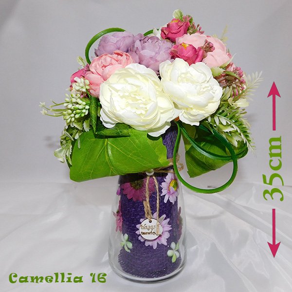 Camellia vase bouquet in transparent glass with optimistic artificial blooms